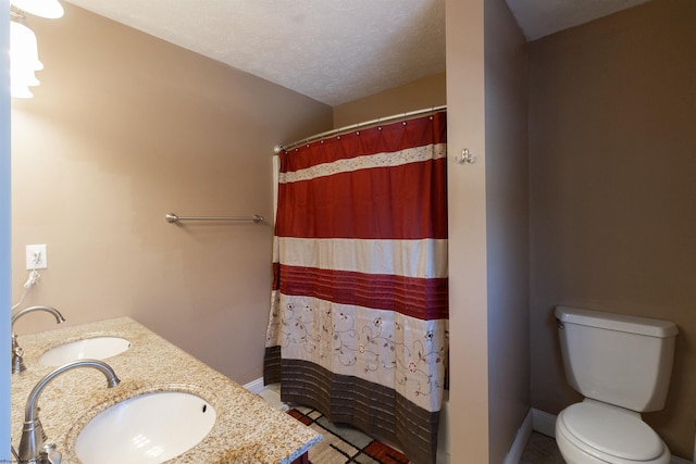 full bath with double vanity, a sink, toilet, and a shower with curtain