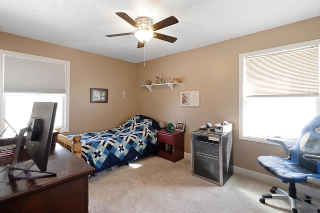 bedroom with light carpet, ceiling fan, and baseboards