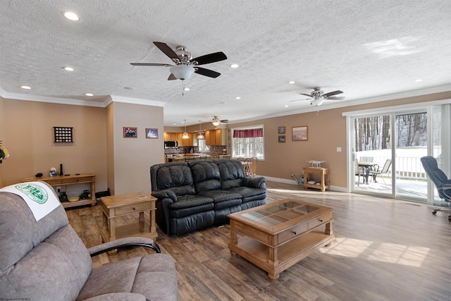 living area featuring recessed lighting, crown molding, light wood-style flooring, and baseboards