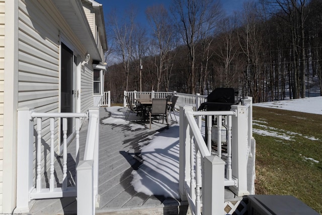 snow covered deck featuring outdoor dining area