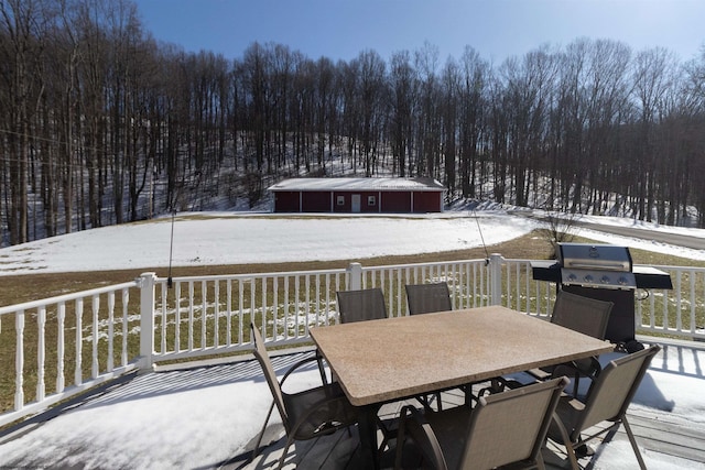 snow covered deck featuring outdoor dining area and area for grilling