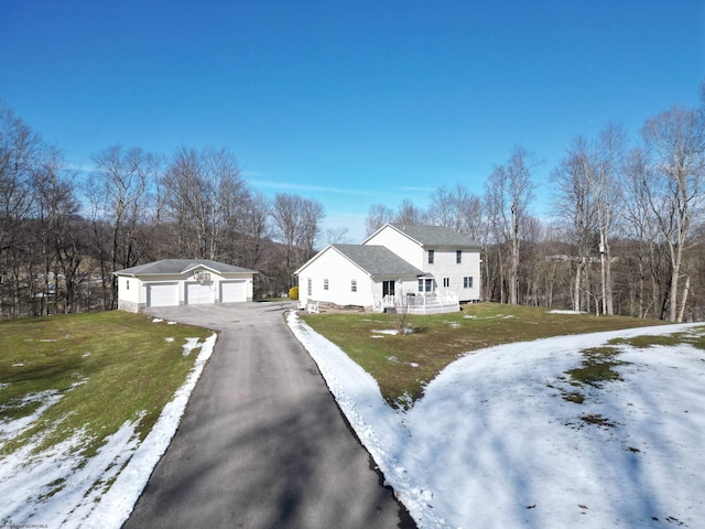 view of front of home with a yard, a detached garage, and an outdoor structure