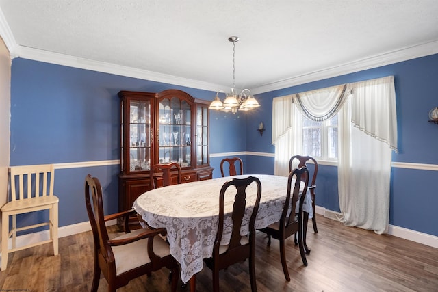 dining room featuring baseboards, crown molding, a chandelier, and dark wood-style flooring