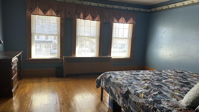 bedroom featuring radiator heating unit and wood finished floors