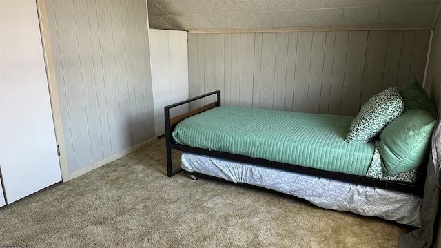 carpeted bedroom with wooden walls