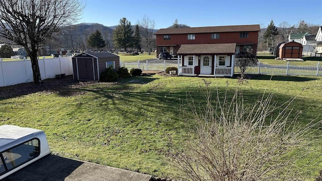 view of yard featuring an outbuilding, a storage unit, and a fenced backyard