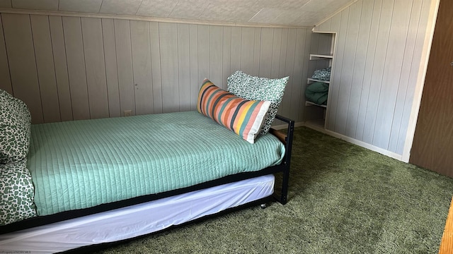 carpeted bedroom featuring lofted ceiling and wooden walls