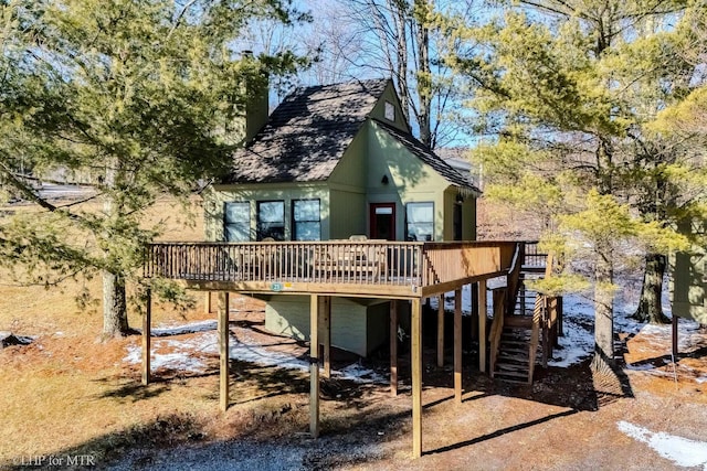 rear view of house featuring stairway, a carport, and a wooden deck