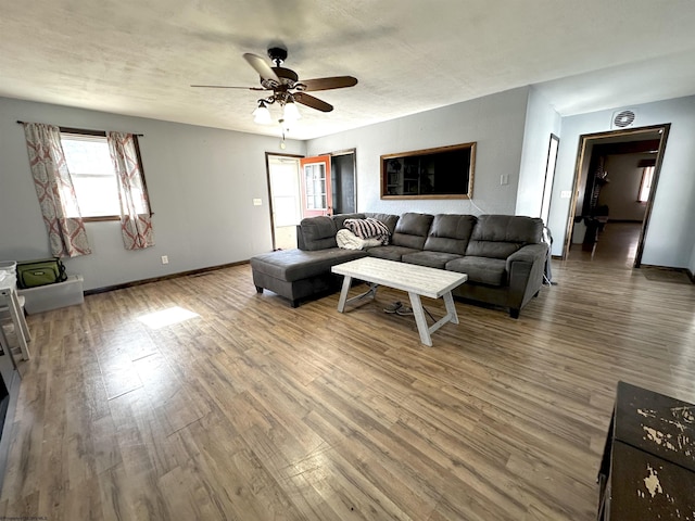 living room with ceiling fan, wood finished floors, and baseboards