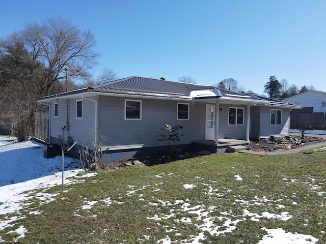 single story home with metal roof and a lawn