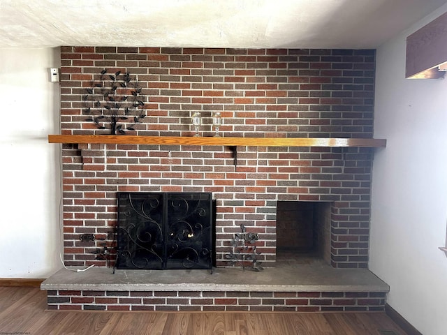 details with a brick fireplace, wood finished floors, and baseboards