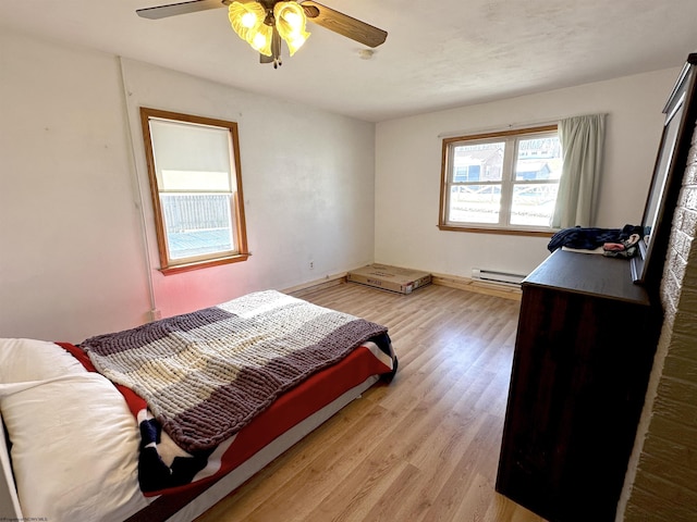 bedroom featuring a baseboard radiator, a ceiling fan, and light wood-style floors