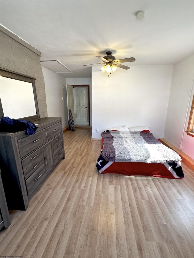 bedroom featuring a ceiling fan, baseboards, and light wood finished floors