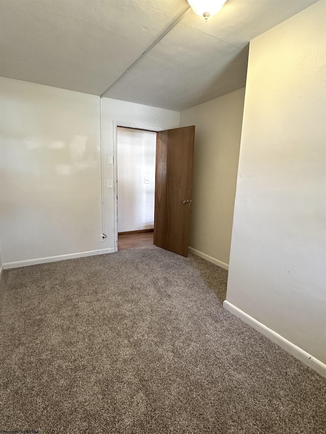 empty room with baseboards and carpet flooring