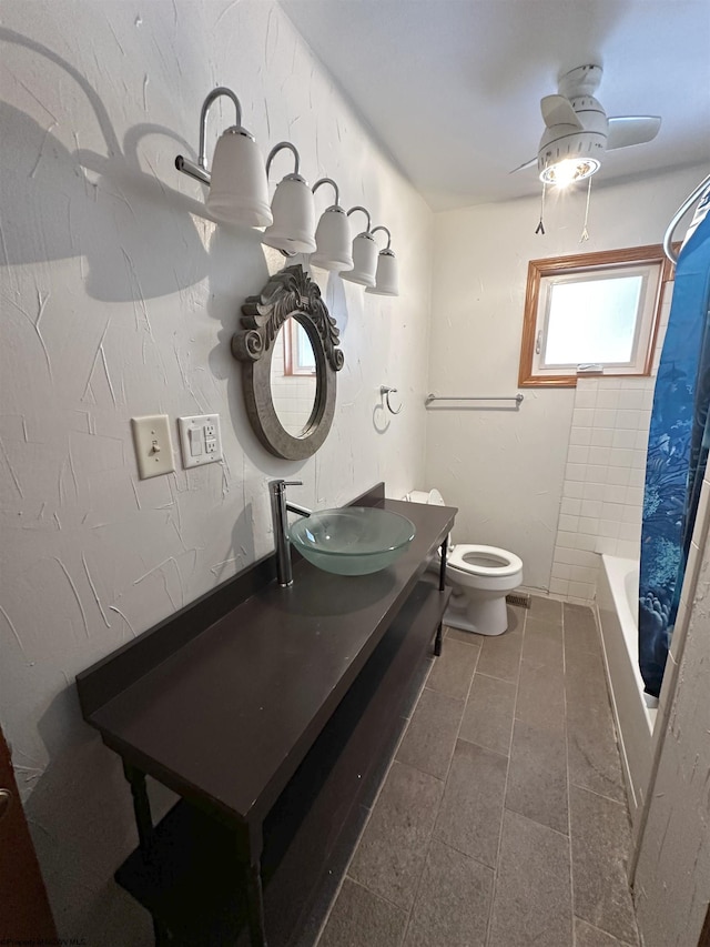 full bathroom featuring shower / bath combination with curtain, vanity, toilet, and a ceiling fan