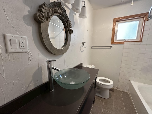 full bath featuring toilet, vanity, a bath, and tile patterned floors