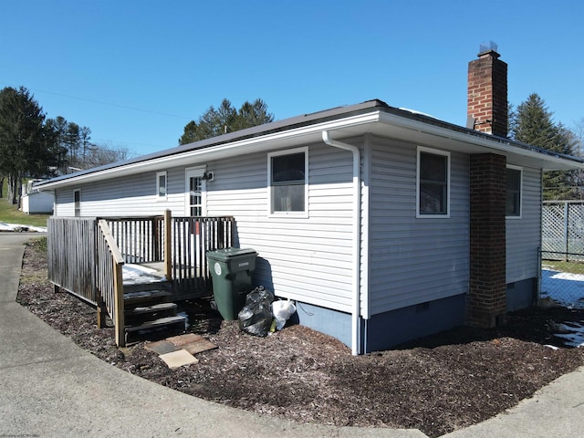 view of front of house with crawl space, a chimney, and a wooden deck