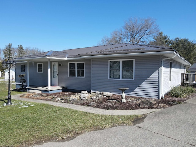 ranch-style house featuring metal roof and a front lawn