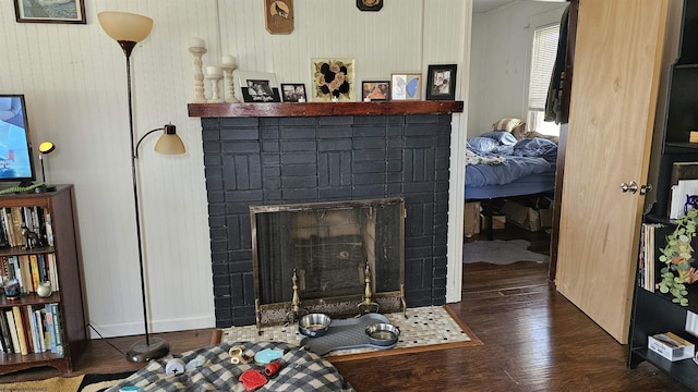 interior details featuring a brick fireplace and wood finished floors