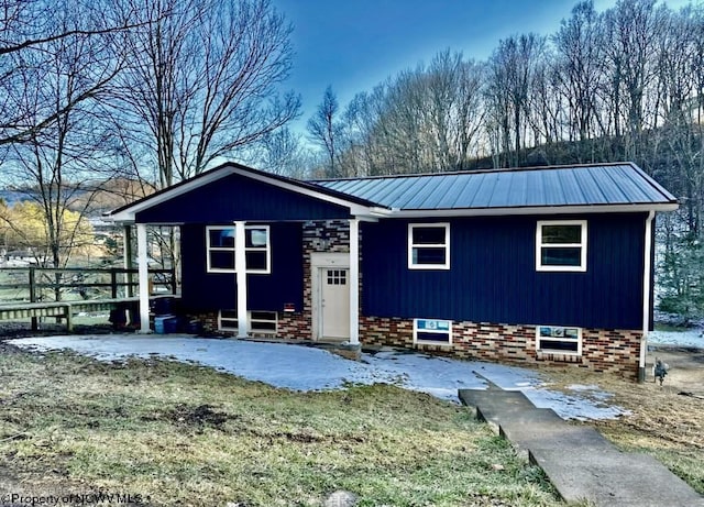 exterior space with metal roof, a patio, and brick siding