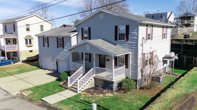 view of front of home featuring a garage, a shingled roof, concrete driveway, covered porch, and a front lawn