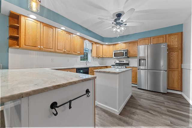 kitchen featuring ceiling fan, wood finished floors, stainless steel appliances, open shelves, and a sink