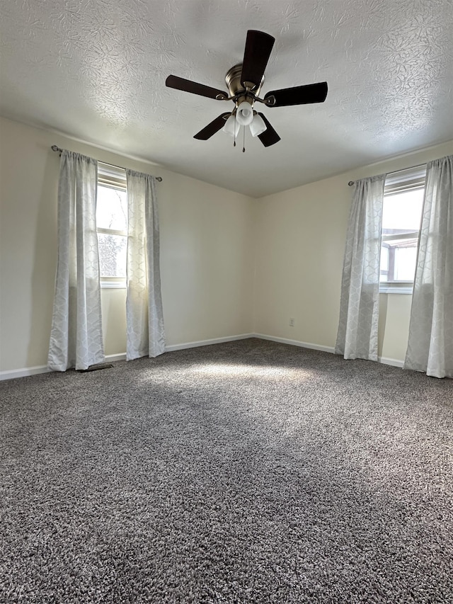 unfurnished room featuring baseboards, a healthy amount of sunlight, a textured ceiling, and carpet flooring