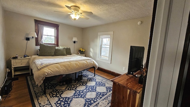 bedroom featuring dark wood-style floors, baseboards, a ceiling fan, and a textured ceiling