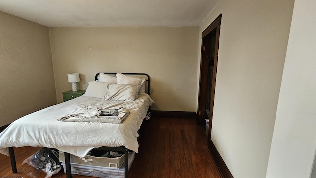 bedroom with baseboards and wood finished floors