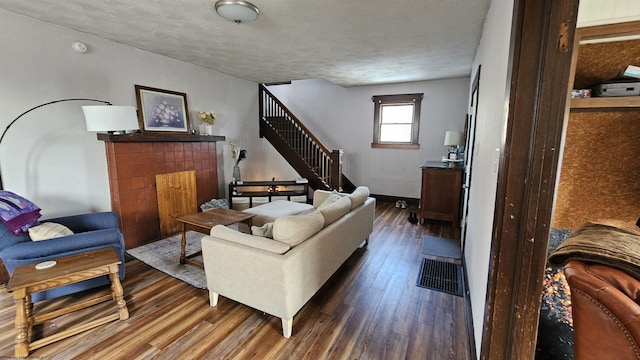 living room featuring stairs, baseboards, and wood finished floors