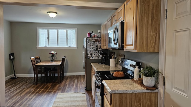 kitchen featuring stainless steel appliances, light countertops, dark wood-style flooring, and brown cabinetry