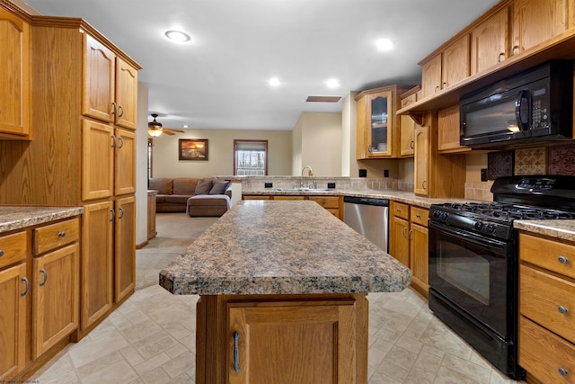 kitchen featuring a center island, glass insert cabinets, open floor plan, a sink, and black appliances