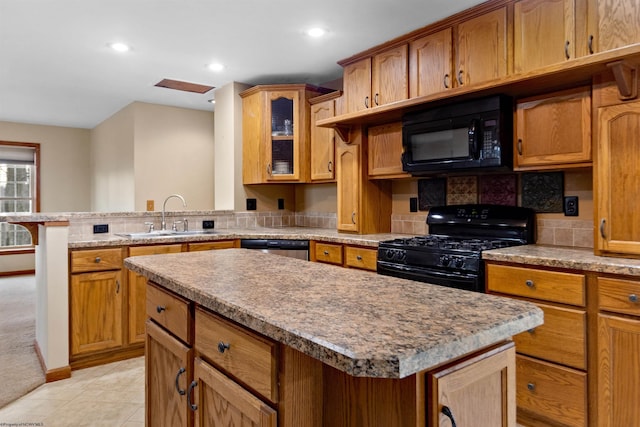 kitchen with light tile patterned floors, a kitchen island, a sink, black appliances, and glass insert cabinets