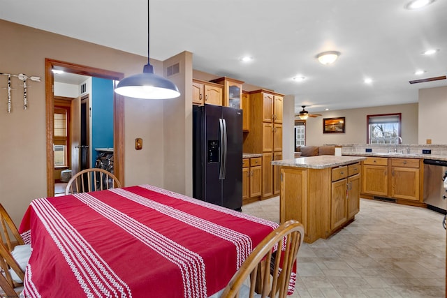 kitchen with a sink, black fridge with ice dispenser, visible vents, a center island, and dishwasher