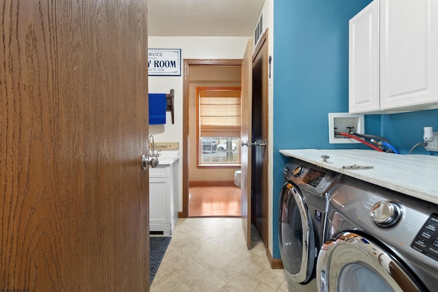 clothes washing area featuring cabinet space, baseboards, visible vents, and washing machine and clothes dryer