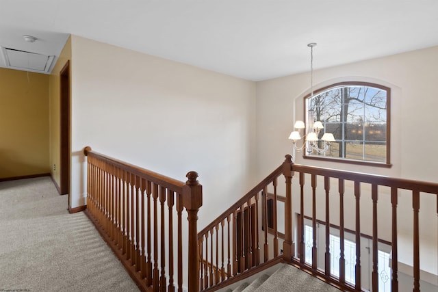 stairs featuring attic access, baseboards, a chandelier, and carpet flooring