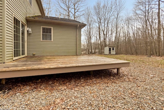 wooden deck featuring a shed and an outbuilding