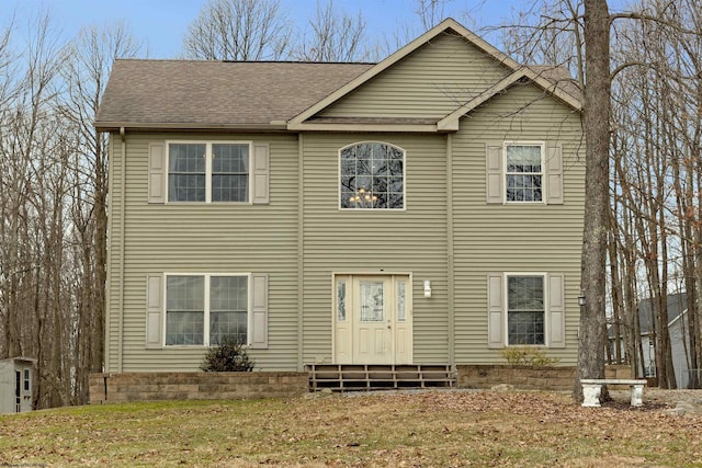 colonial home with a shingled roof and entry steps