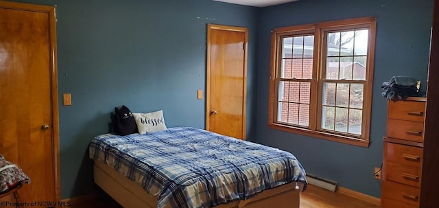 bedroom with a baseboard radiator and baseboards
