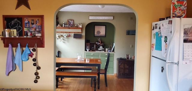 interior space with wood finished floors and freestanding refrigerator
