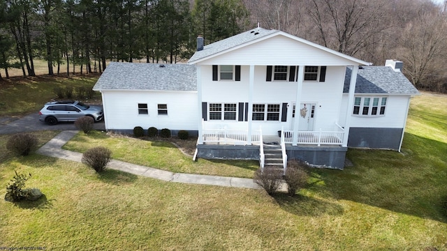 view of front of home featuring roof with shingles, a chimney, and a front yard