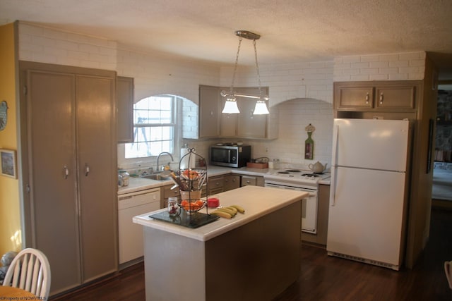 kitchen with light countertops, white appliances, a sink, and dark wood finished floors