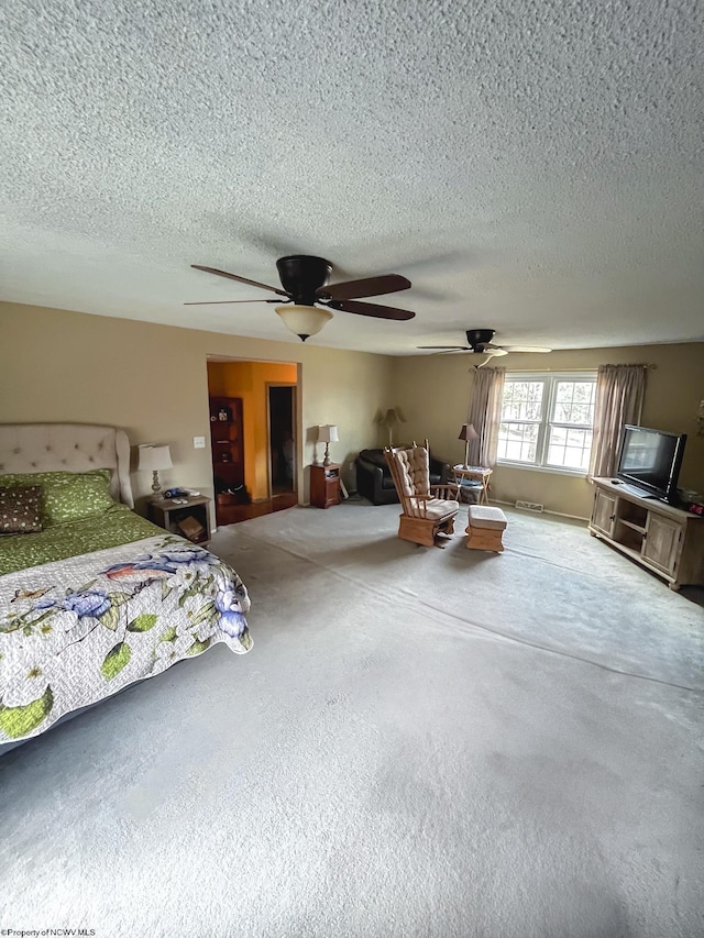 bedroom featuring carpet, ceiling fan, and a textured ceiling