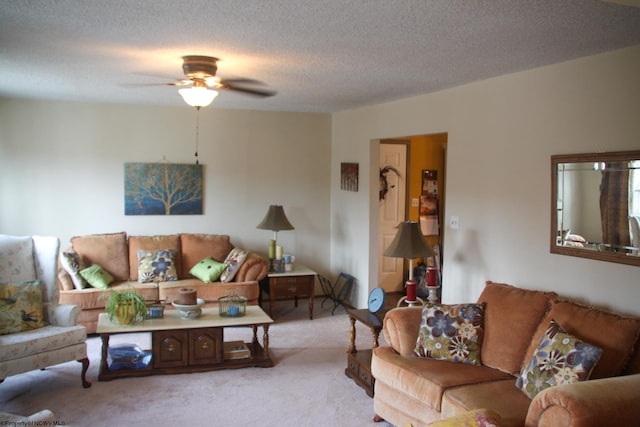 living area with light carpet, a ceiling fan, and a textured ceiling