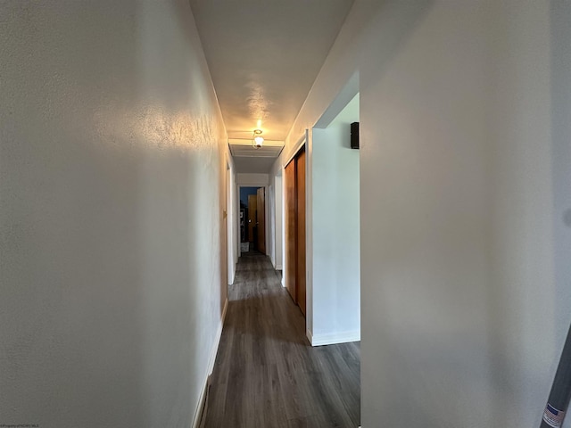 hallway with dark wood-type flooring and baseboards