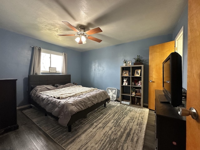 bedroom featuring dark wood-style flooring, ceiling fan, and baseboards