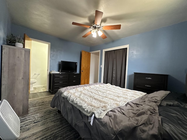 bedroom with dark wood-type flooring, a closet, ensuite bath, and a ceiling fan