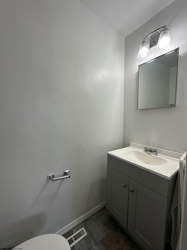 bathroom with toilet, baseboards, visible vents, and vanity