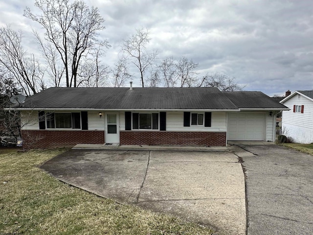 ranch-style house featuring driveway, brick siding, a front lawn, and an attached garage