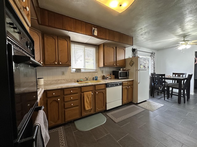 kitchen featuring light countertops, white appliances, a sink, and decorative backsplash